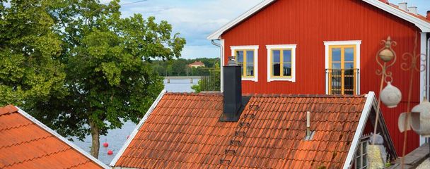 Tradiční švédské domy zbarvené falu červeným barvivem. Dlážděné střechy. Prázdná ulice. - Fotografie, Obrázek