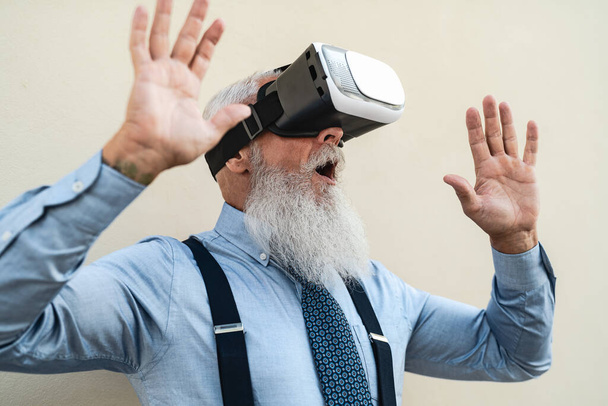 Senior fashion man having fun playing with innovated virtual reality glasses - Tech gaming entertainment concept - Zdjęcie, obraz