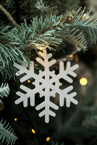 Bellissimo fiocco di neve e luci incandescenti sull'albero di Natale, primo piano - Foto, immagini