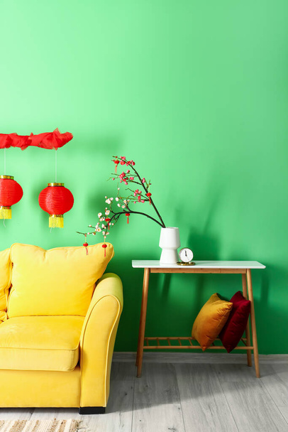 Интерьер современного номера с диваном, столом и декором для празднования китайского Нового года - Фото, изображение
