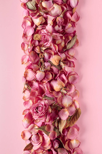 Flowers composition. Frame made of dried rose flowers, petals, and leaves. Top view with copy space. - Foto, immagini