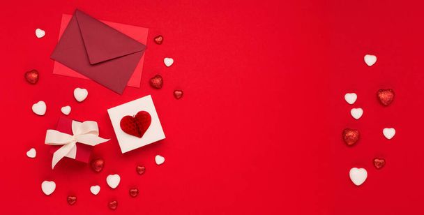 Festive holiday greeting card for Valentines, Birthday, Woman, Mothers Day. Red white hearts and gift boxes on red background. Valentines day banner concept. Flat lay, top view, copy space. - Fotó, kép