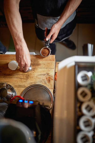 A bird-eye view on barman's hands working behind the bar in a working atmosphere. Coffee, beverage, bar - Fotó, kép
