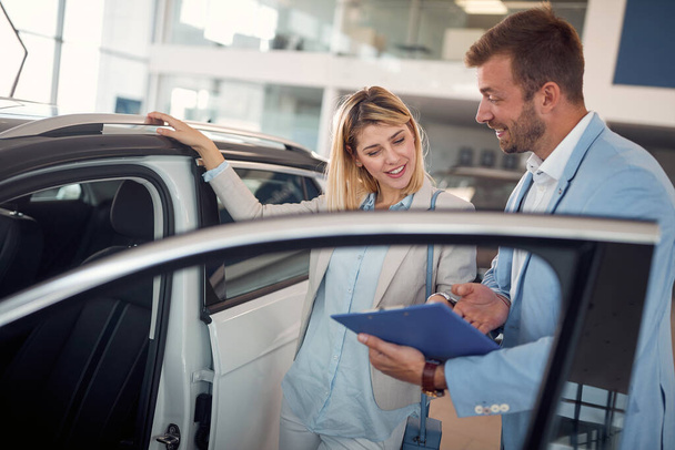 Successful businesswoman buying a new car in the store - 写真・画像