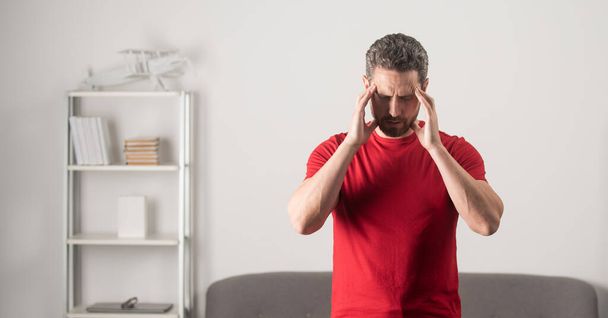 Reifer Mann leidet unter Kopfschmerzen und fühlt sich unglücklich, kopiert Raum, Migräne - Foto, Bild