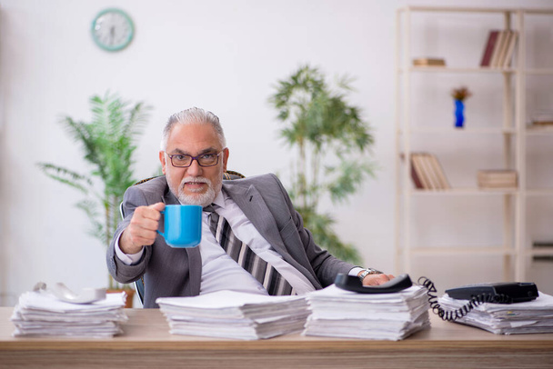 Vecchio dipendente maschio e troppo lavoro in ufficio - Foto, immagini