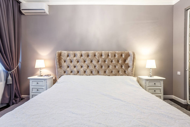 luxury hotel bedroom. Bed with carriage coupler headboard - Fotografie, Obrázek