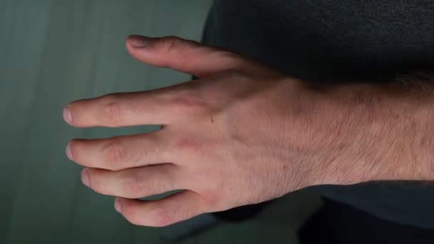 мужчина изучает свою руку 4k кадр - Кадры, видео
