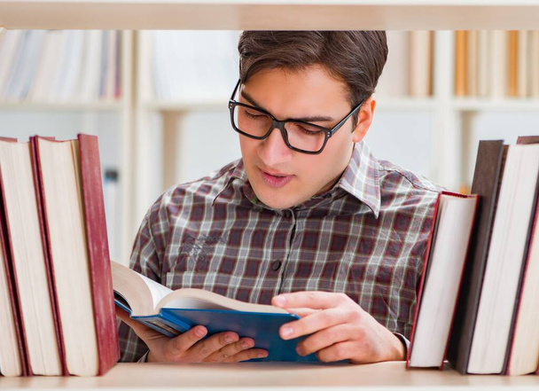 Jonge student op zoek naar boeken in universiteitsbibliotheek - Foto, afbeelding