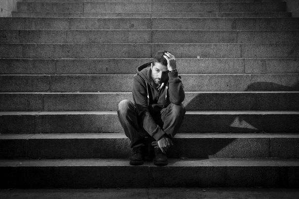 νεαρός άνδρας έχασε στην κατάθλιψη που κάθεται στο έδαφος δρόμου σκάλες από μπετό - Φωτογραφία, εικόνα