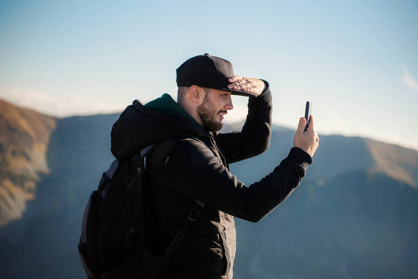 Handsome young man takeson smartphone mountain scenery.  Kasprowy Wierch. Poland. - Foto, Bild