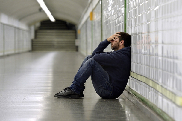 młody człowiek w depresji, siedząc na tunel ulicy metra ziemi - Zdjęcie, obraz