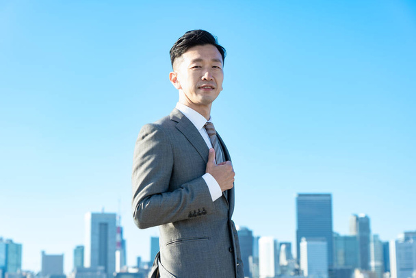 Портрет бізнесмена, блакитне небо і будівлі великого міста
 - Фото, зображення