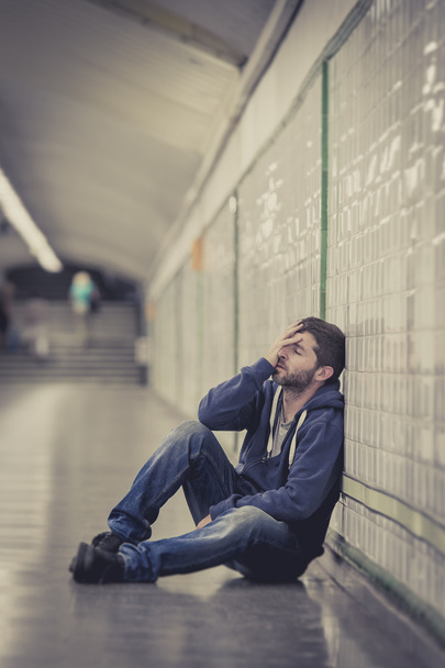 Jeune homme perdu dans la dépression assis dans le tunnel souterrain de la rue
 - Photo, image