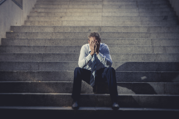 бізнесмен плаче, загублений в депресії, сидячи на вуличних бетонних сходах
 - Фото, зображення