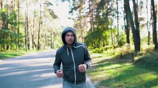 Ένας άνθρωπος σε ένα πάρκο ή δάσος τρέχει στο δρόμο. Έννοια αργής κίνησης. - Πλάνα, βίντεο
