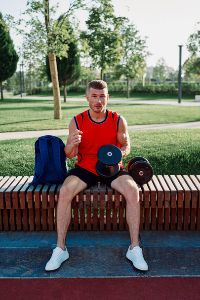 athletic man in red t-shirt in fitness park - Zdjęcie, obraz