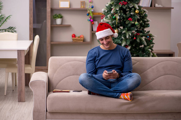 Νεαρός γιορτάζει τα Χριστούγεννα μόνος στο σπίτι - Φωτογραφία, εικόνα