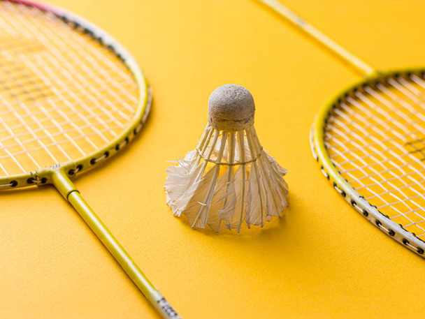 Badminton racket and White Feather Shuttlecock with a  colour green background stock isolated image.  - Foto, afbeelding