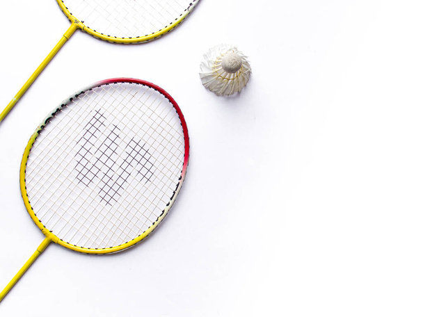 rakieta Badminton i biały pióro wahadłowiec z kolor zielony tło zapasy izolowane obraz.  - Zdjęcie, obraz