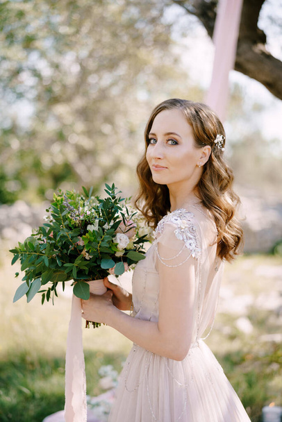 Smiling bride with a bouquet of flowers. Portrait - Фото, зображення