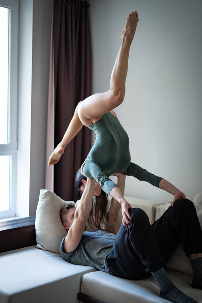 romantic couple making acrobatic trick in the bedroom. Concept of sex, relationship and romance - Photo, image