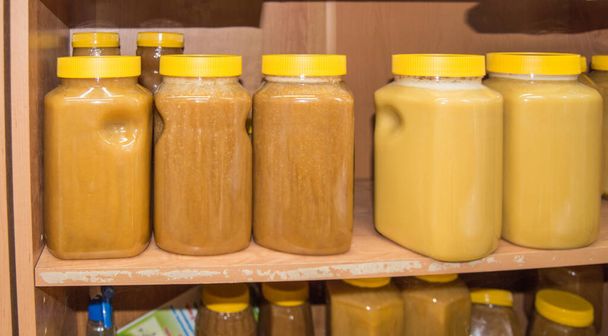 Φυσικό μέλι σε διάφορα βάζα σε ξύλινο ράφι, σουβενίρ στην αγορά του χωριού. - Φωτογραφία, εικόνα