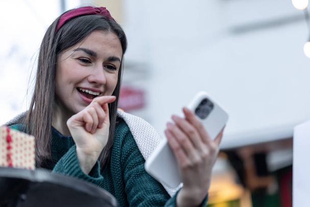 Vonzó fiatal nő használ okostelefon, Karácsonyi online vásárlás. - Fotó, kép