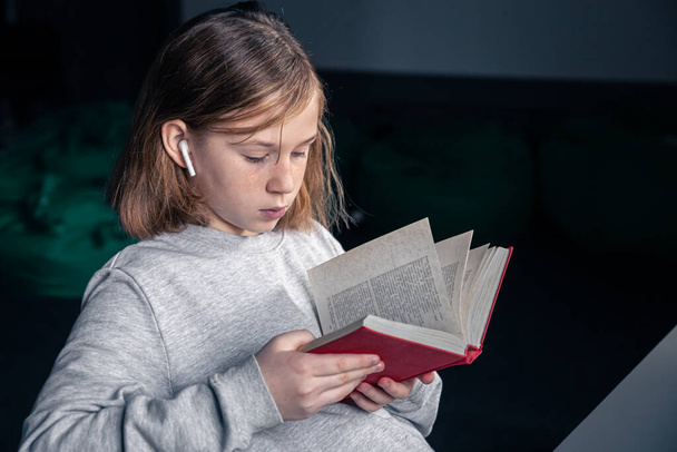 Серйозна маленька дівчинка читає книгу, розмитий фон
. - Фото, зображення