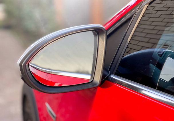 Зеркало крупным планом для просмотра слепых пятен красной машины. Информация о машине - Фото, изображение