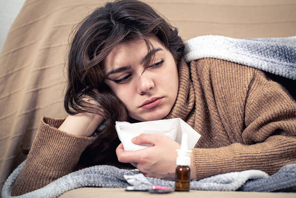 Mujer joven enferma con medicamentos se encuentra en la cama, resfriados y tratamiento en el hogar. - Foto, imagen