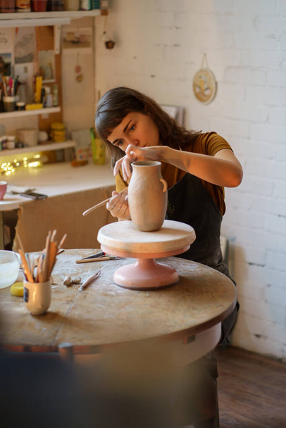 Junge Kunststudentin oder Keramik-Atelierbesitzerin entwirft Vase für Meisterkurs in Werkstatt - Foto, Bild