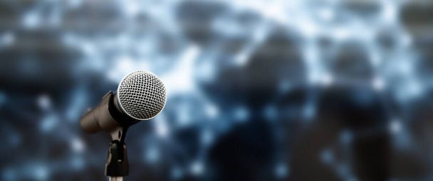 Sfondi per parlare in pubblico, primo piano il microfono sullo stand per le prestazioni del palco di presentazione del discorso degli altoparlanti con sfocatura e sfondo leggero bokeh. - Foto, immagini
