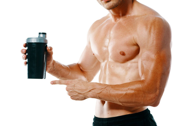 athletic man with a pumped-up torso drink bottle sportspit - Fotó, kép