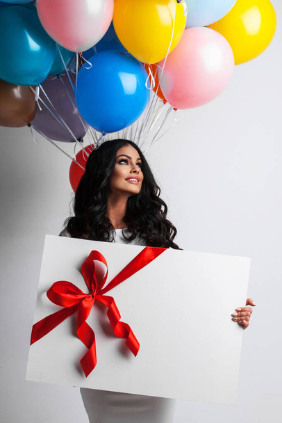 Young smiling woman with balloons and big gift box holiday gift - Valokuva, kuva
