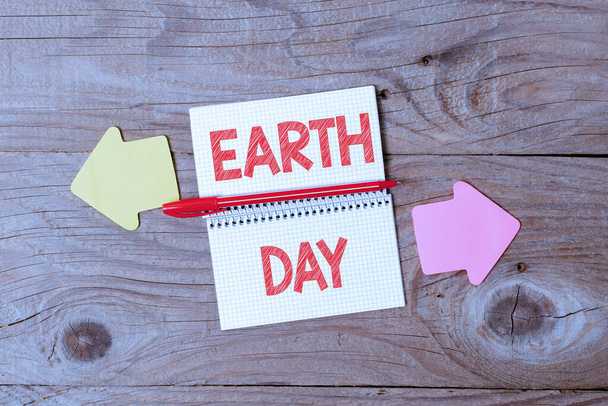 Bildunterschrift: Tag der Erde. Internet-Konzept Weltweite Feier des Umweltschutzes Anzeige verschiedenfarbiger Aufkleber-Notizen auf flachem Hintergrund - Foto, Bild