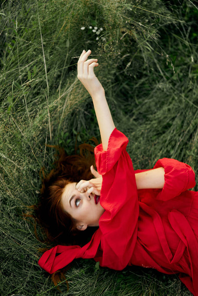 woman in red dress lies on the grass fresh air nature freedom - Foto, Bild