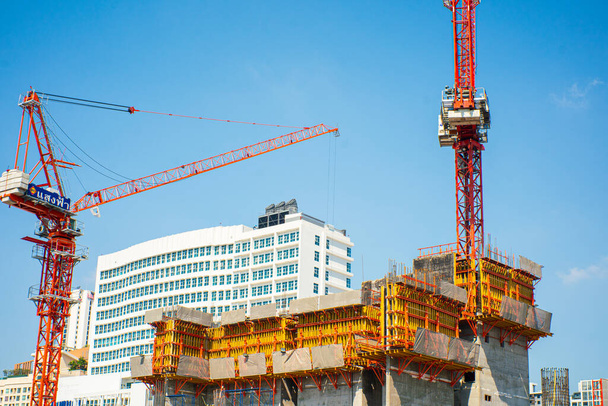 Edificio de obra con grúa en la ciudad moderna edificio de oficinas de gran altura cielo azul - Foto, Imagen