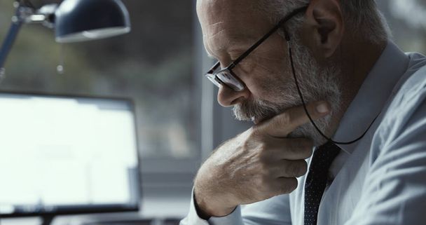 Focused businessman wearing glasses and working in the office - Foto, immagini