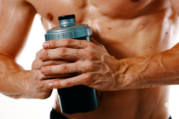 athletic man with a pumped-up torso drink bottle sportspit - Фото, изображение