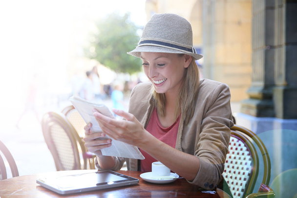Girl in coffee shop reading newspaper - Foto, immagini