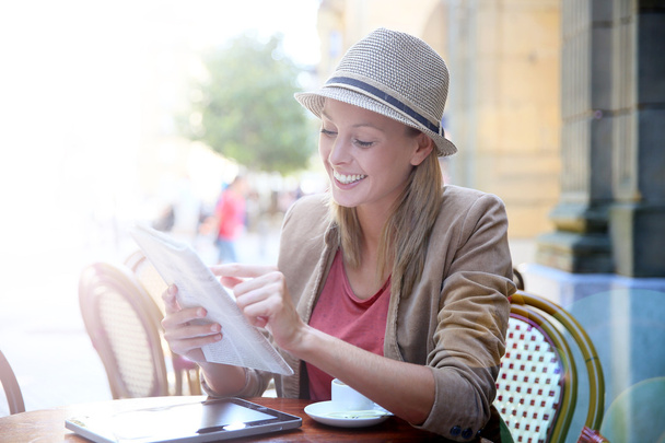 Girl in coffee shop reading newspaper - Foto, Imagen