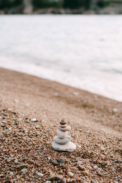 Пирамида камней на галечном пляже у воды - Фото, изображение
