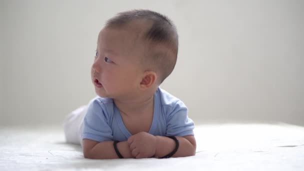 Bebek yatağa uzandı ve etrafına bakınmaya meraklı - Video, Çekim