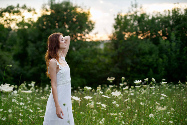 Woman in white dress in a field flowers sun nature freedom - Fotografie, Obrázek