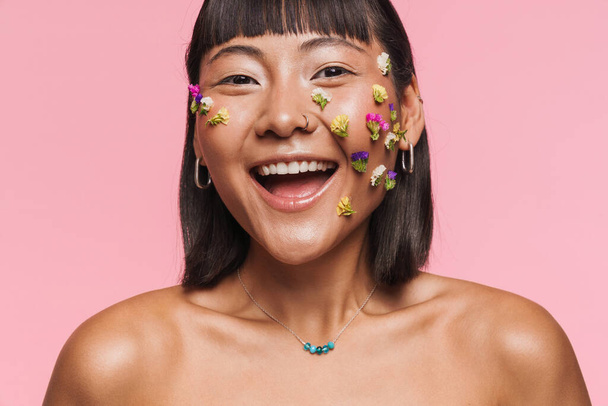 Beauty portrait of a smiling happy young brunette asian woman with makeup facial decoration over wall background - Foto, Bild