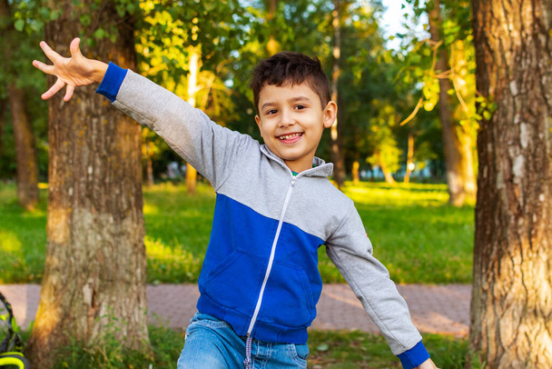 χαρούμενο αγόρι 6 ετών περπατά στο πάρκο το καλοκαίρι - Φωτογραφία, εικόνα