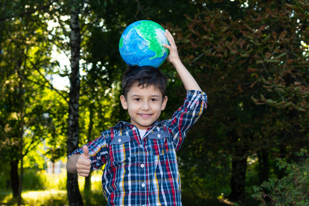 happy boy holds a globe on his head - Zdjęcie, obraz