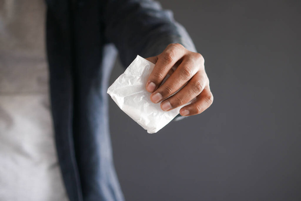 drug addiction concept with hand holding heroine packet on black backgrund  - Фото, изображение