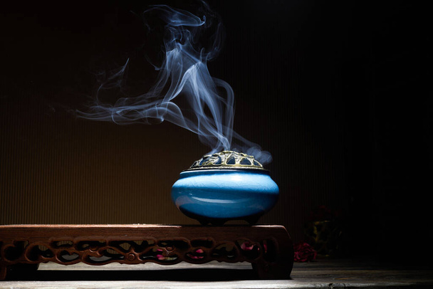 Smoke from burning incense sticks standing on lotus incense holder - Foto, Imagen